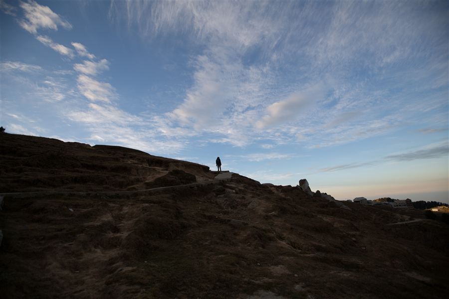 A lone figure on a hilltop under a big sky